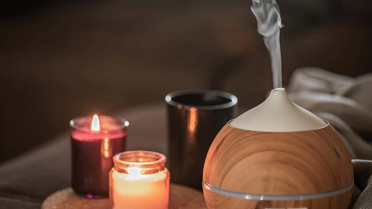 oil-diffuser-near-burning-candles-aromatherapy-health-care-concept - Saintdeland Fragrance