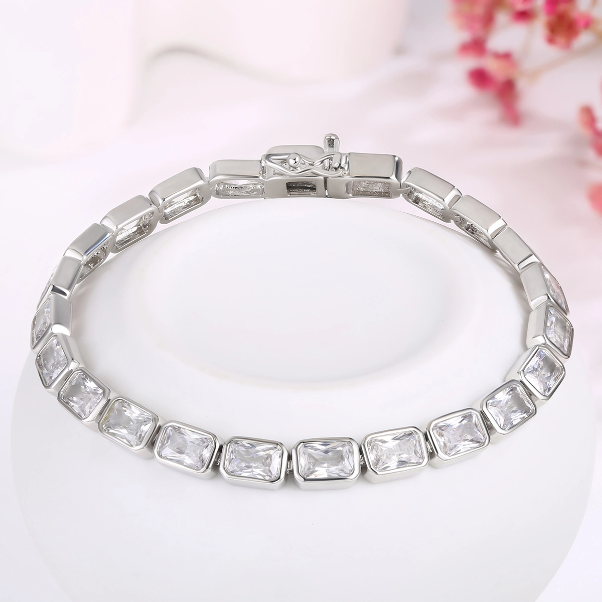 Cubic zirconia tennis bracelet displayed on a pale pink studio pedestal - Zhefan Jewelry