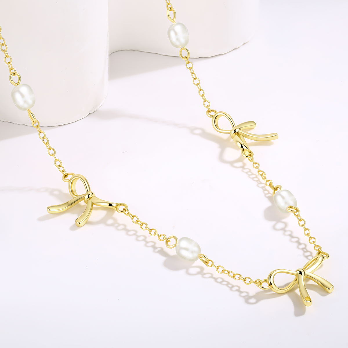 Freshwater pearl bow necklace with polished bow pendant and delicate chain