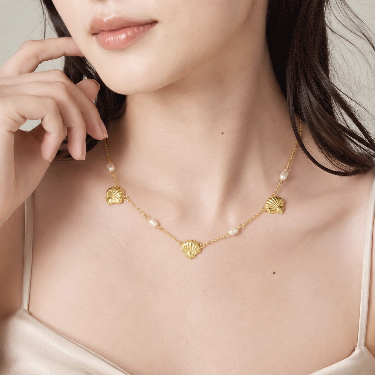 Collana di perle in vermeil d'oro - Produttore e modello: Zhefan Jewelry Modella indossa una collana di perle e conchiglie color oro per la presentazione B2B della collezione di gioielli Zhefan Jewelry.