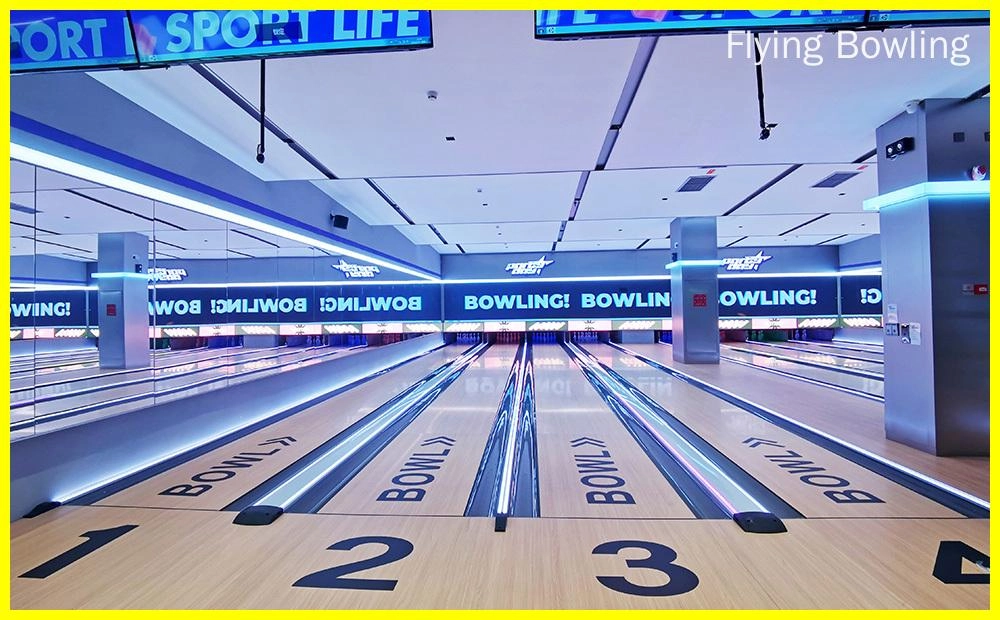 Fly Bowling - An image of a bowling alley with four lanes. The lanes are made of wood and have a shiny, waxed surface. The pins are set up at the end of each lane. There is a large screen at the end of the alley that shows the scores of the bowlers.