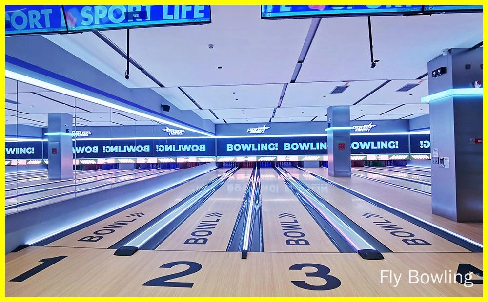 Fly Bowling - machine à quilles Bowling à la mouche - Image d'un bowling à quatre pistes. Les pistes sont en bois et présentent une surface brillante et cirée. Les quilles sont placées au bout de chaque piste. Un grand écran au bout de la piste affiche les scores des joueurs.
