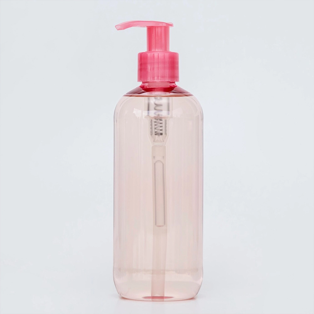 A transparent plastic bottle with a pink pump dispenser.