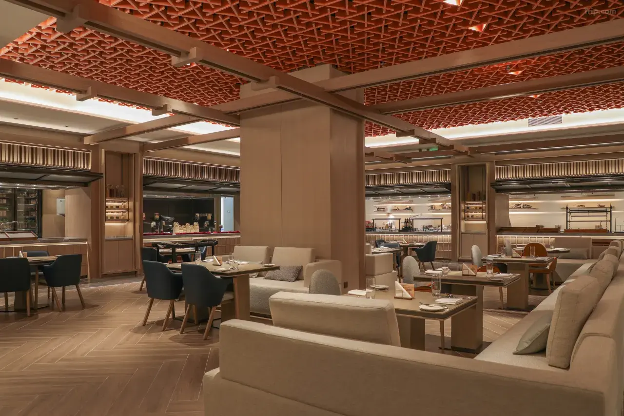 Modern hotel restaurant with wood lattice ceiling and plush booth seating.