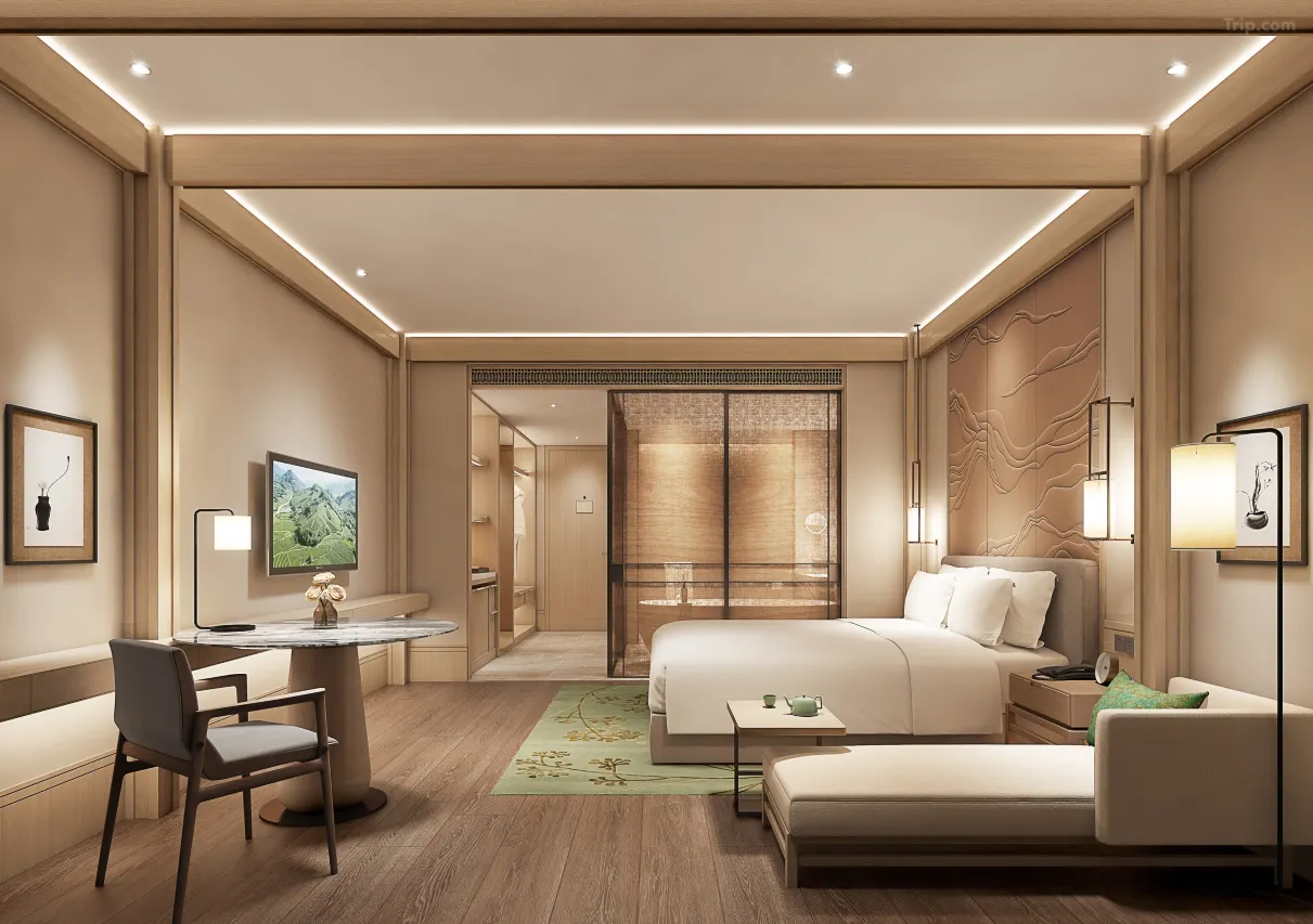 Modern, warm-toned hotel room with a bed, desk, and elegant wood finishes.