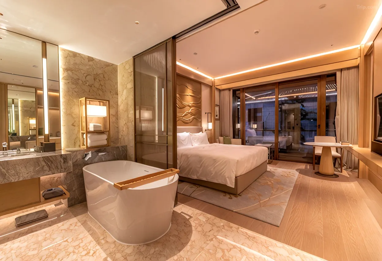 Luxury hotel suite with a marble bathroom and an open-plan bedroom.