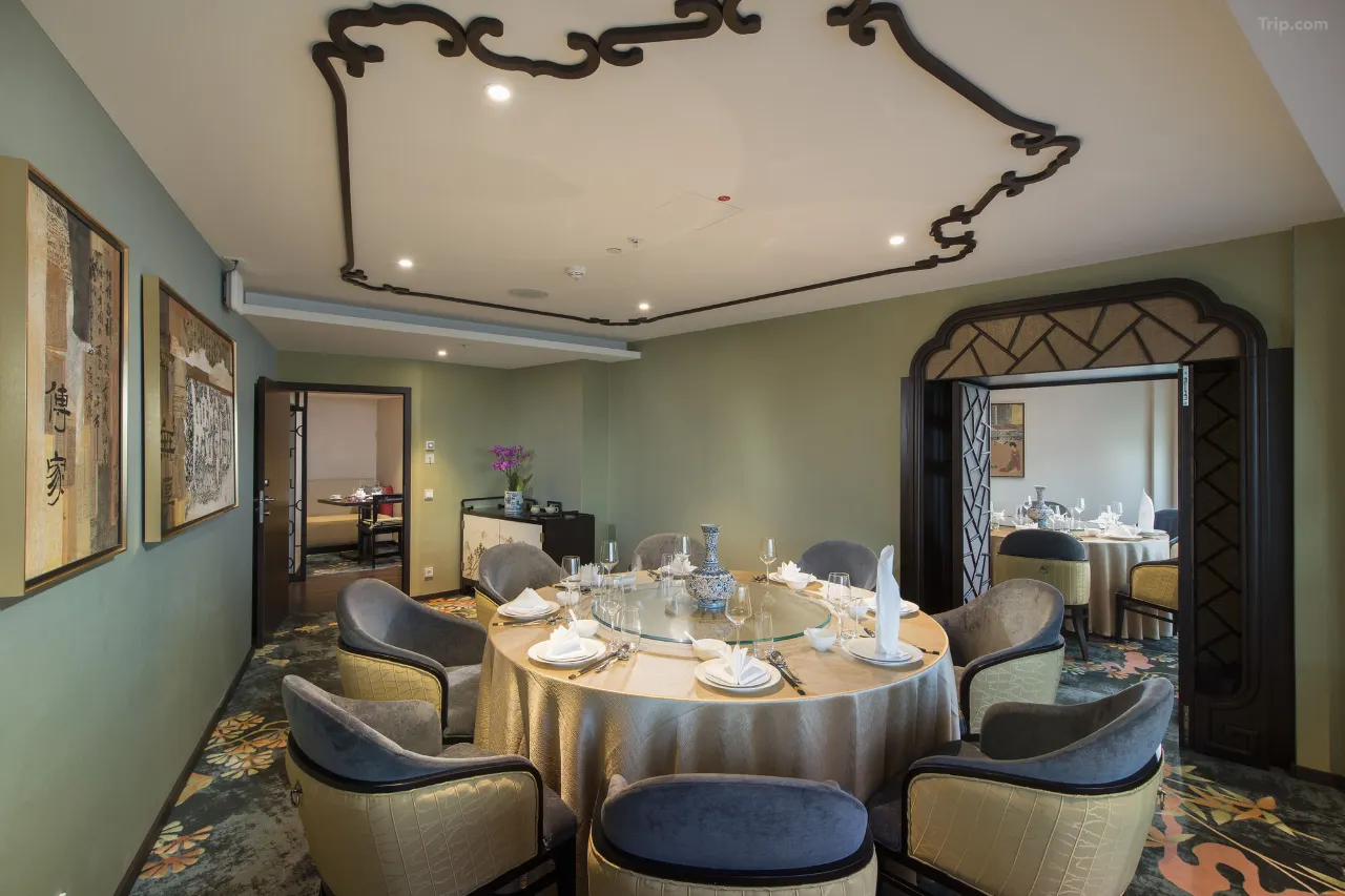 Elegant private dining room with a large round table and ornate ceiling trim.