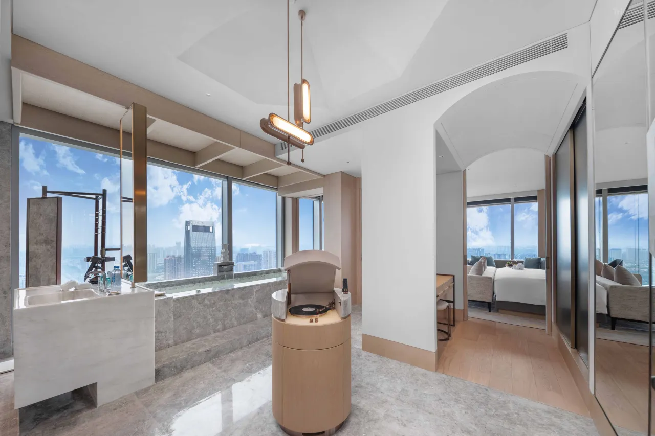 Modern luxury hotel suite with a marble bathroom and city skyline views.