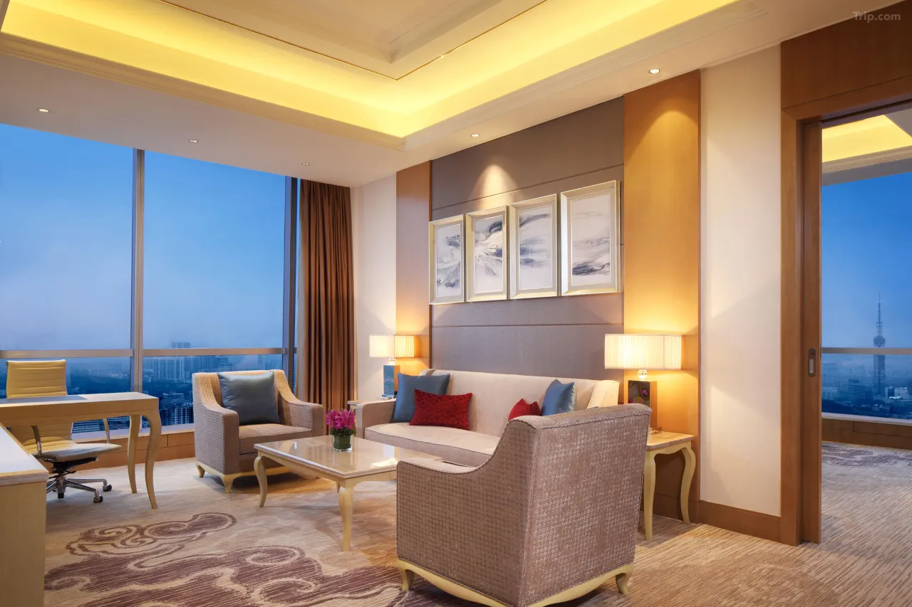 Luxurious hotel suite with a city view, elegant living area, and dedicated workspace.