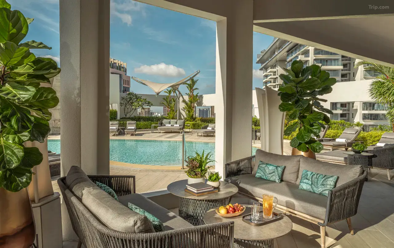 Luxurious poolside lounge with modern seating, fruit, and drinks.