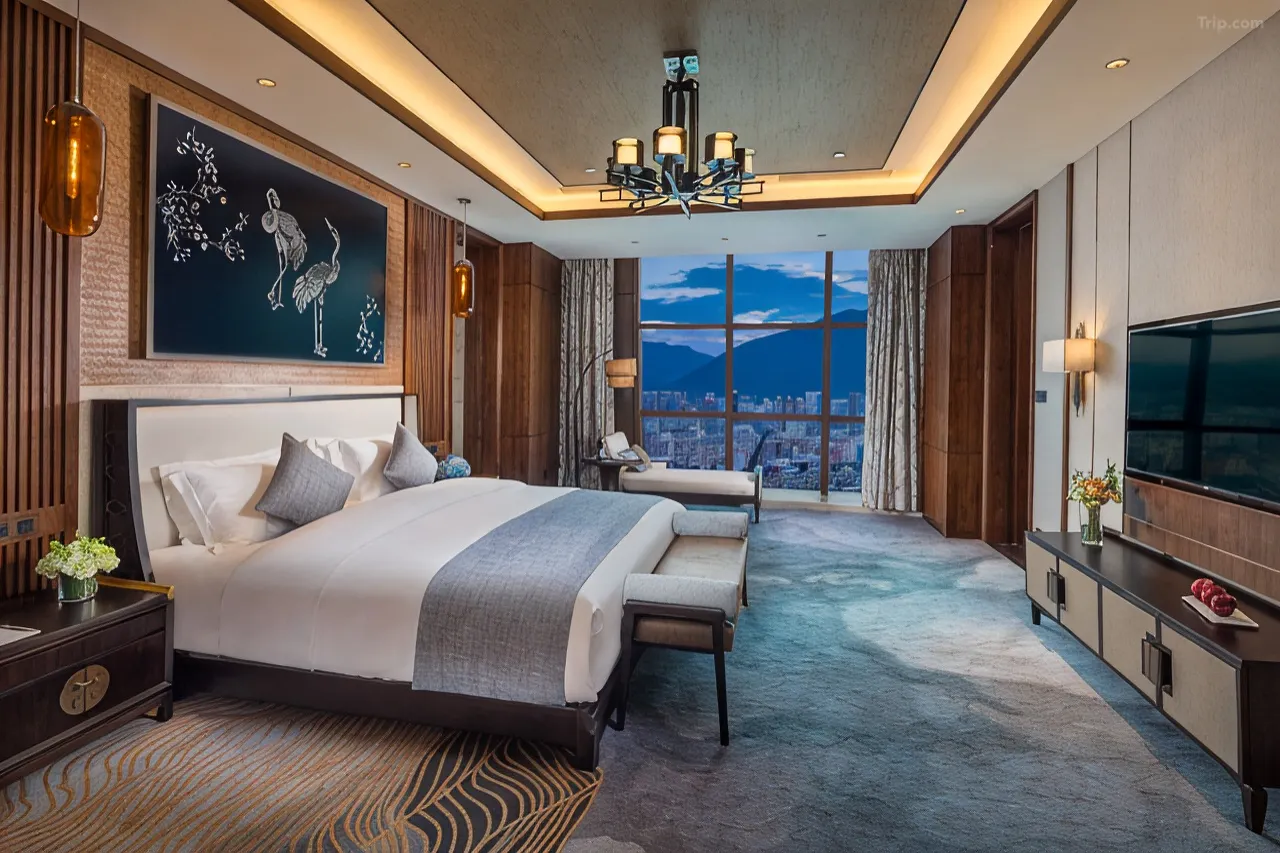 Luxurious hotel bedroom with city views, elegant decor, and a large window.