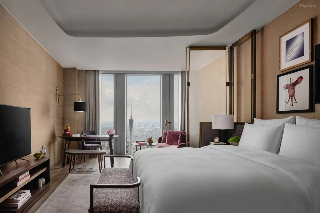 Modern luxury hotel room with a city view and floor-to-ceiling windows.