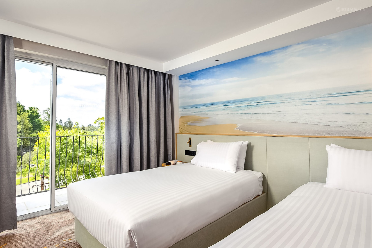 Twin bedroom with ocean mural, balcony overlooking trees. Twin bedroom with ocean mural, balcony overlooking trees.