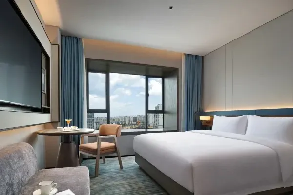 Hotel room interior with a bed and chair.