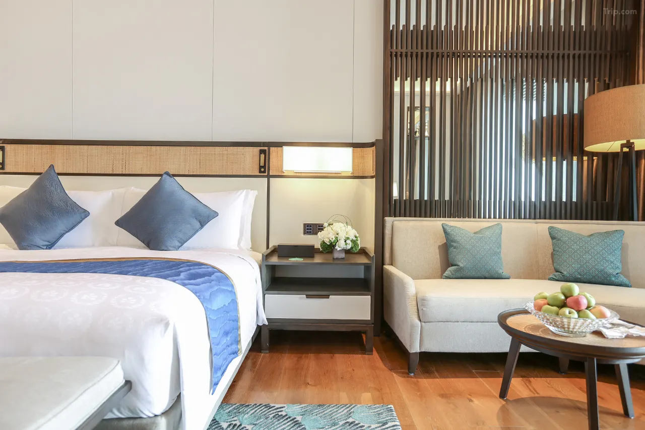 Hotel room featuring a bed, sofa, and decorative wooden screen.