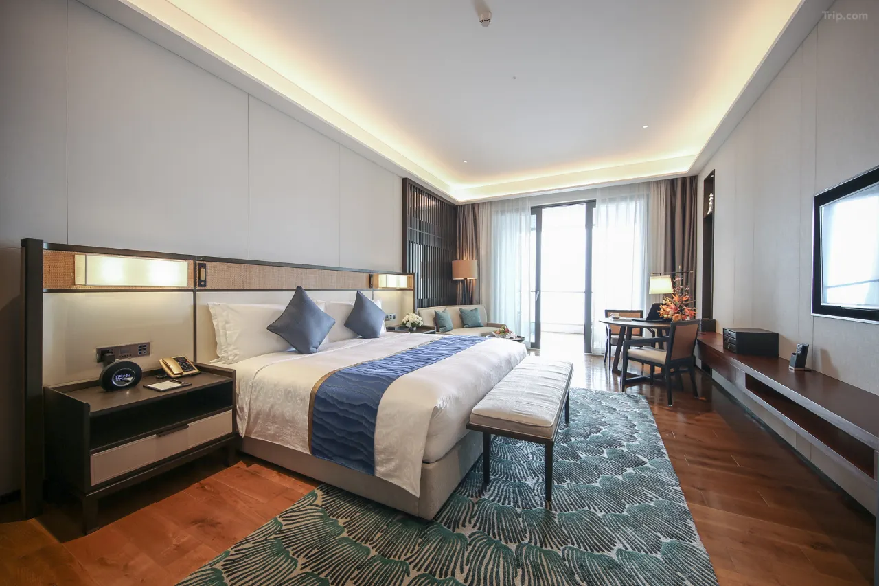 Hotel room featuring a king-sized bed, sitting area, and desk.