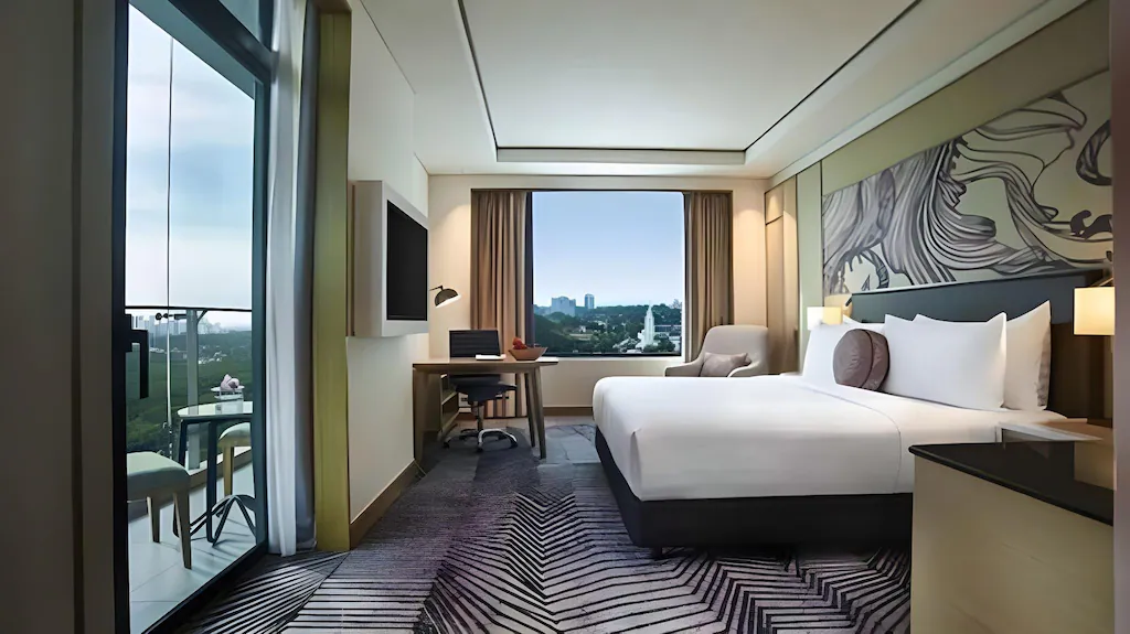 Hotel room with a king bed, desk, balcony, and city view.