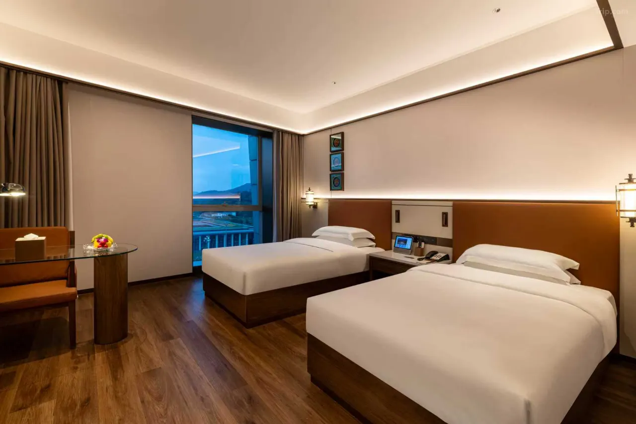 Hotel room with two twin beds, a desk, and a view.