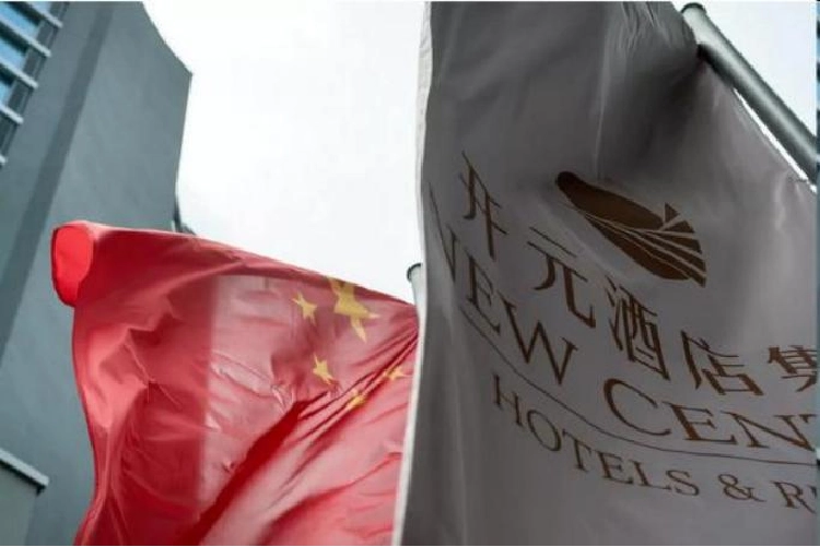 The Chinese national flag and a New Century Hotels flag waving outside.