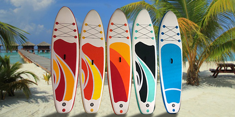 Four inflatable paddle boards on a tropical beach.