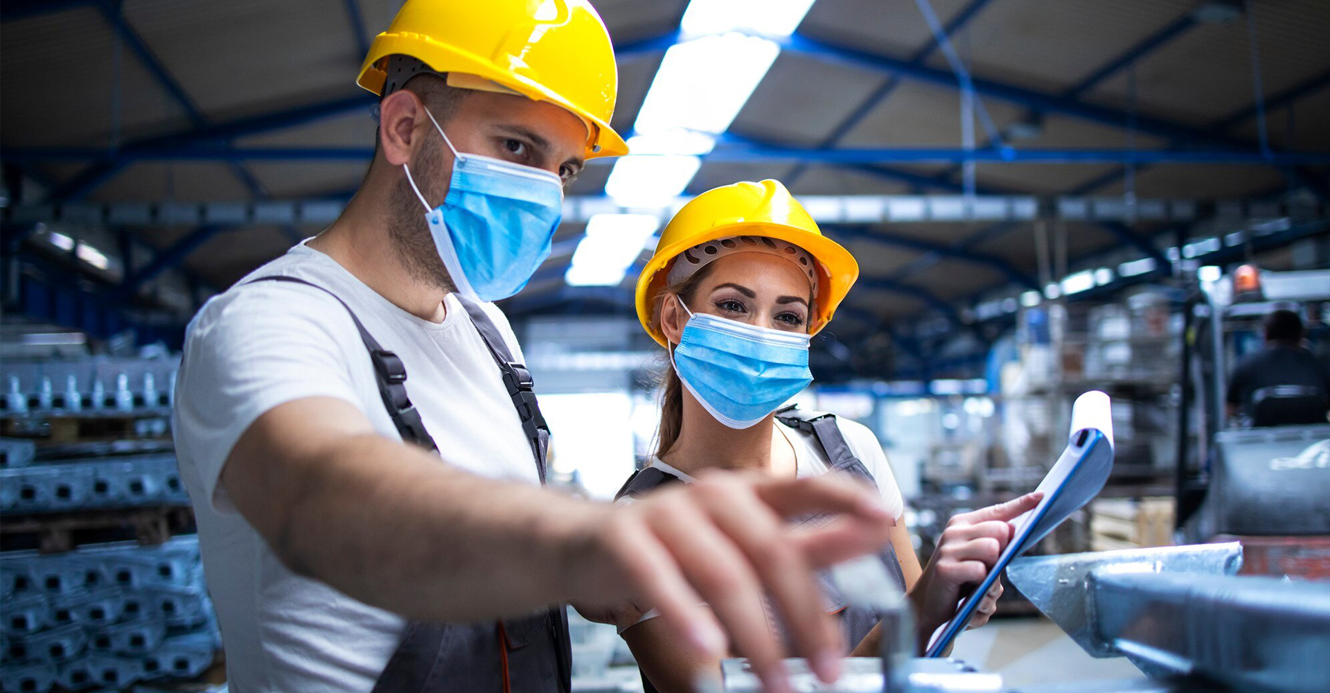 industrial-workers-with-face-masks-protected-against-corona-virus-discussing-about-metal-parts-factory_342744-94