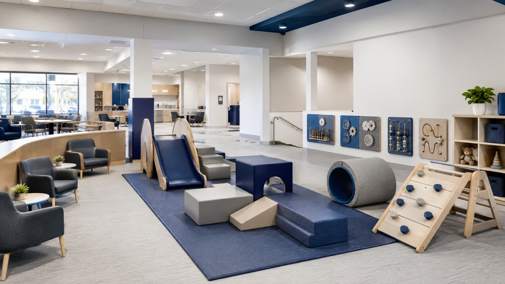 Community center indoor play area showing soft play blocks, wall panels, low slides, storage, and clear supervision sightlines