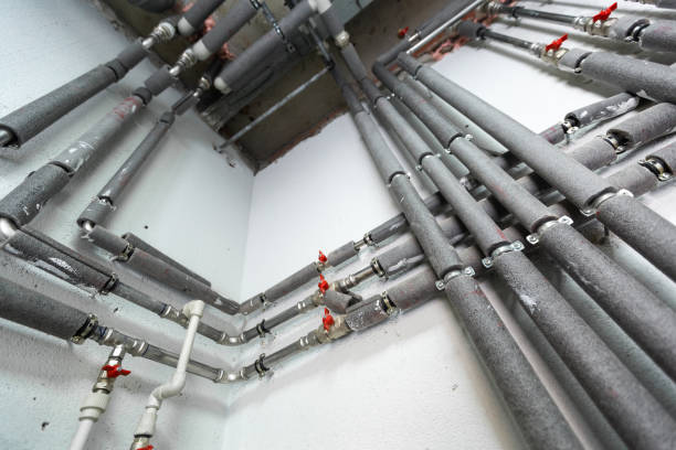 Insulated pipes and valves installed on a white wall. Insulated pipes and valves installed on a white wall.