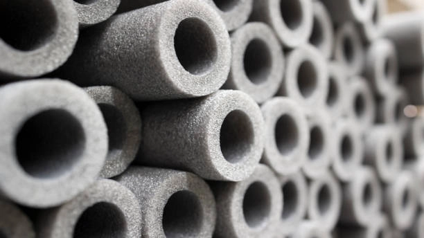 Close-up-view-of-a-stack-of-gray-cylindrical-foam-insulation-tubes. - FUNAS Close-up view of a stack of gray cylindrical foam insulation tubes. - FUNAS