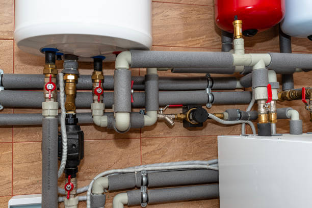 Complex network of insulated pipes and valves connected to water heaters.