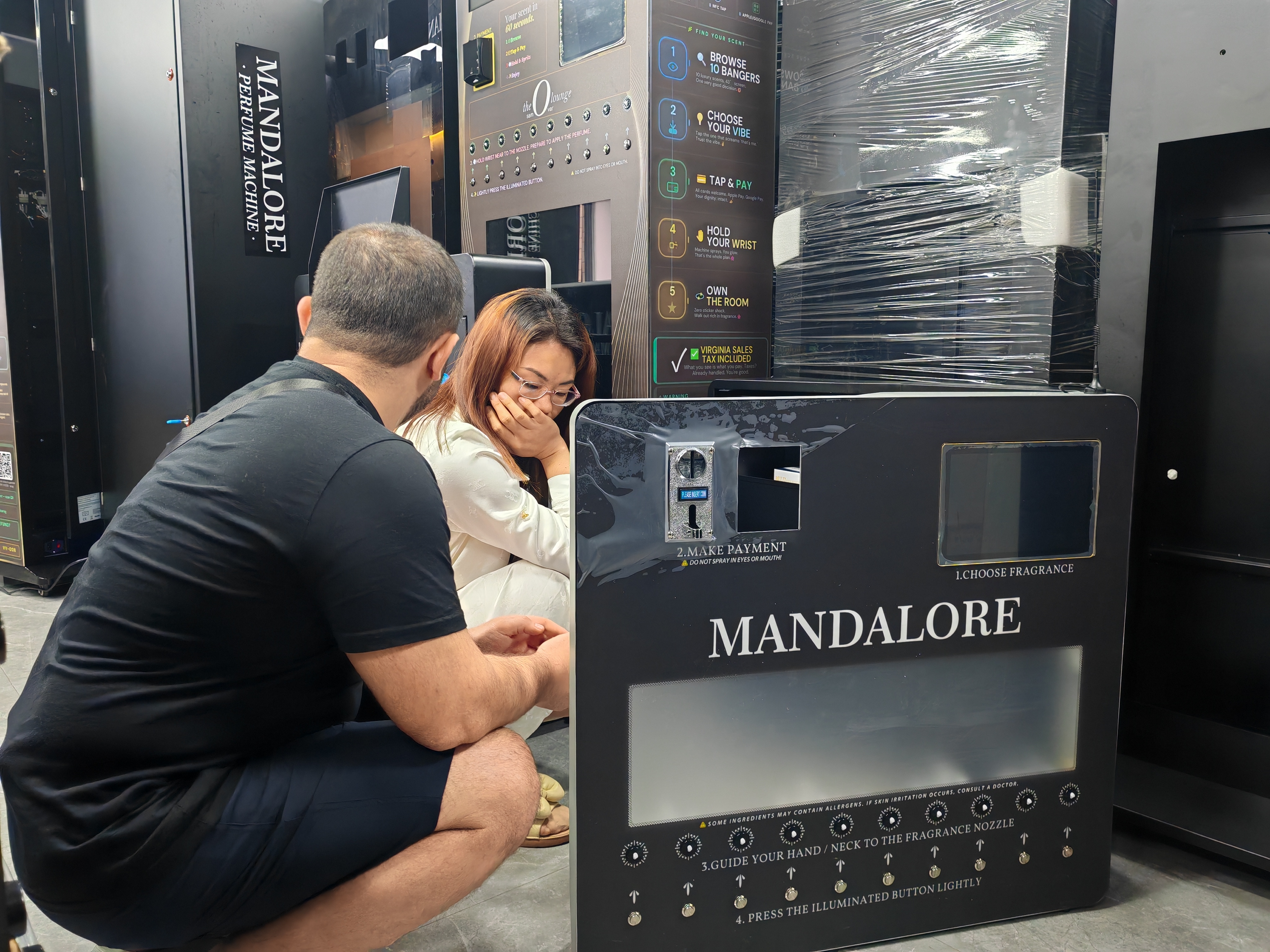 MK salesman Gugu introduced a wall-mounted mini MAKMIK perfume vending machine with 10 spray nozzles to a customer in Tajikistan.