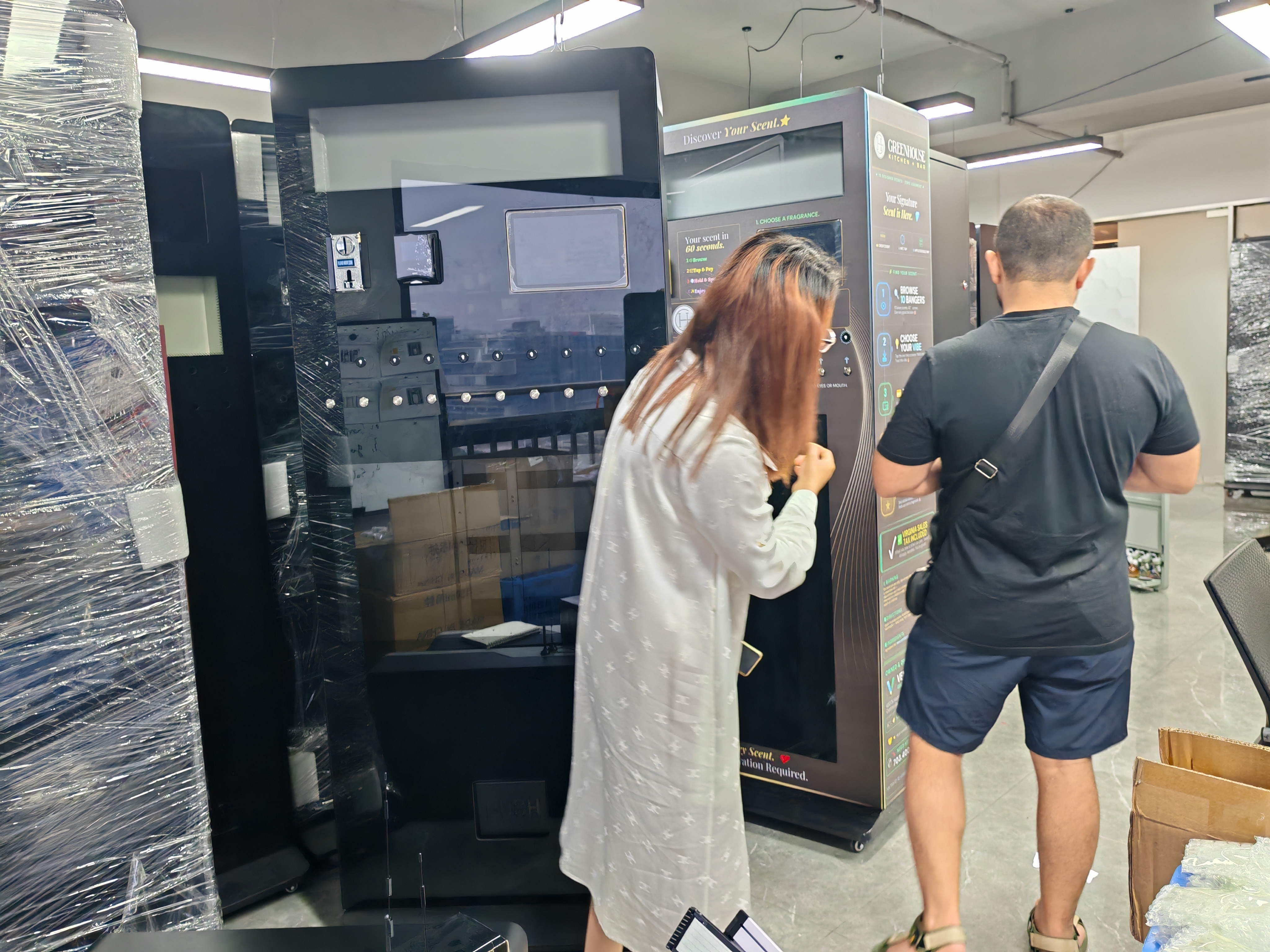 MK salesman Gugu introduced the large, vertical MAKMIK perfume vending machine with 10 nozzles to a customer in Tajikistan.