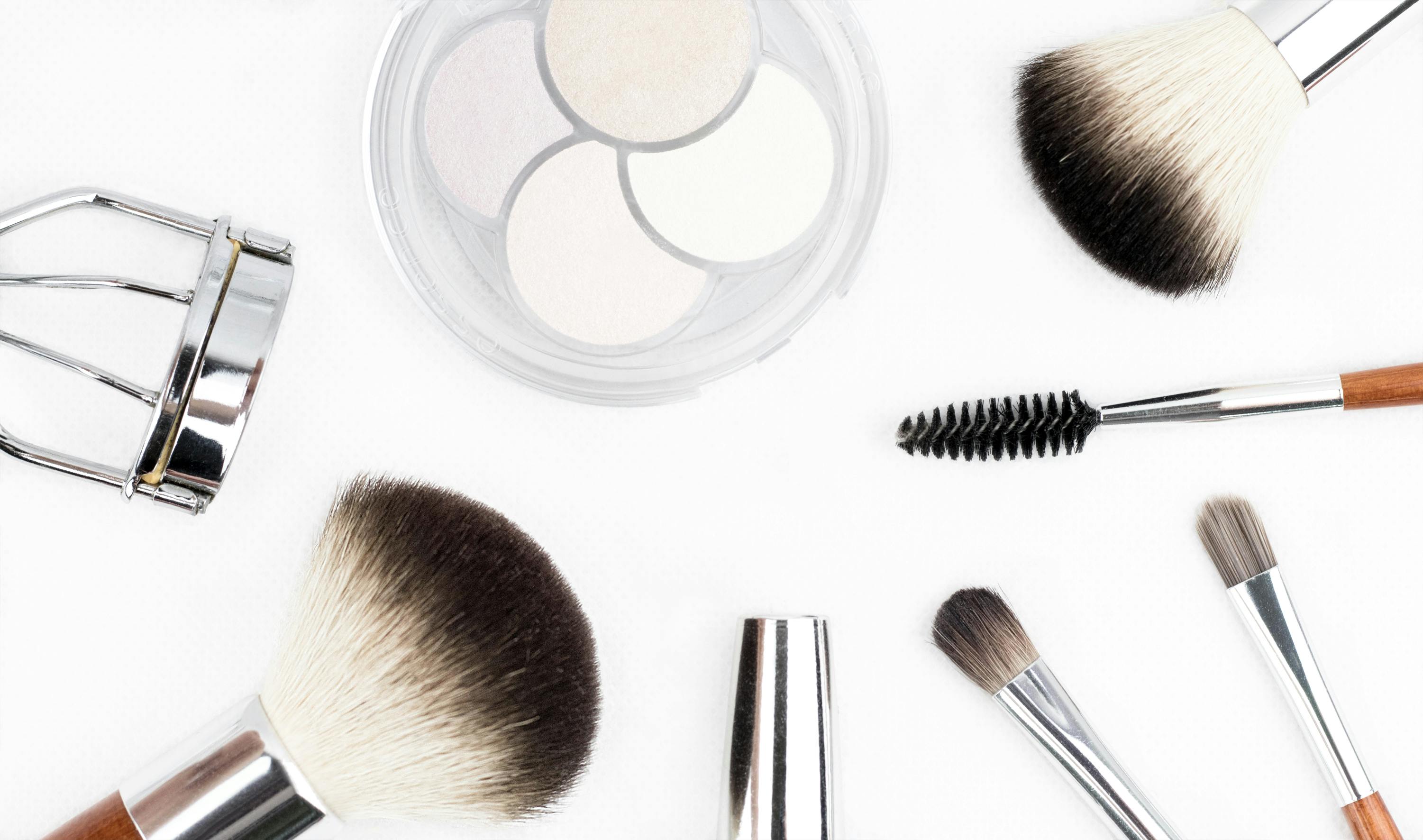 Flat lay of various makeup brushes and tools on a white background. Flat lay of various makeup brushes and tools on a white background.