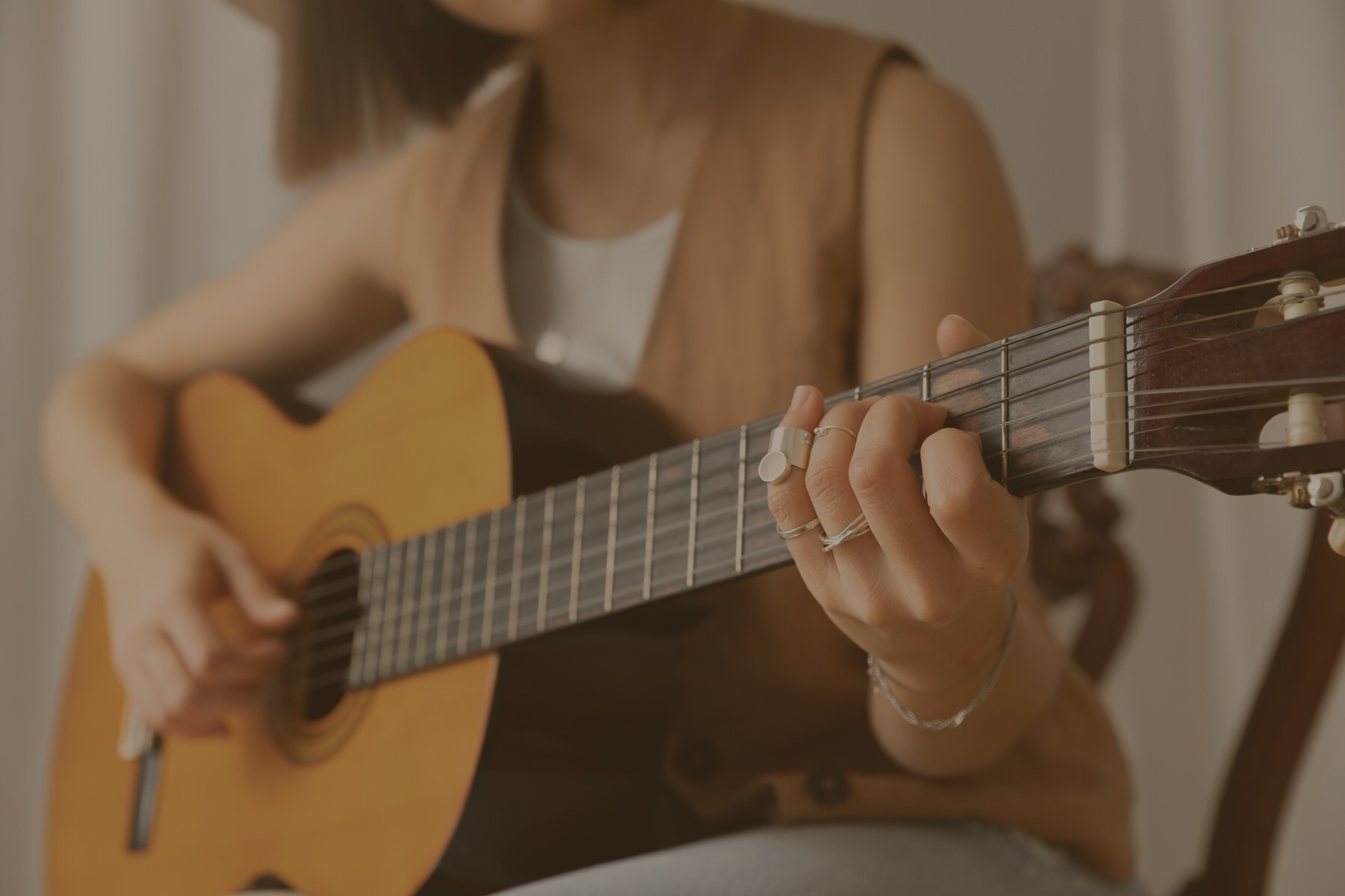 young-woman-playing-guitar-indoors_23-2149140598