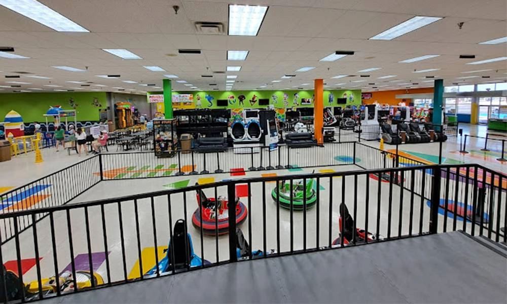 adults riding in glowing bumper cars with a large inflatable ball in the background - H.Q.Amusement