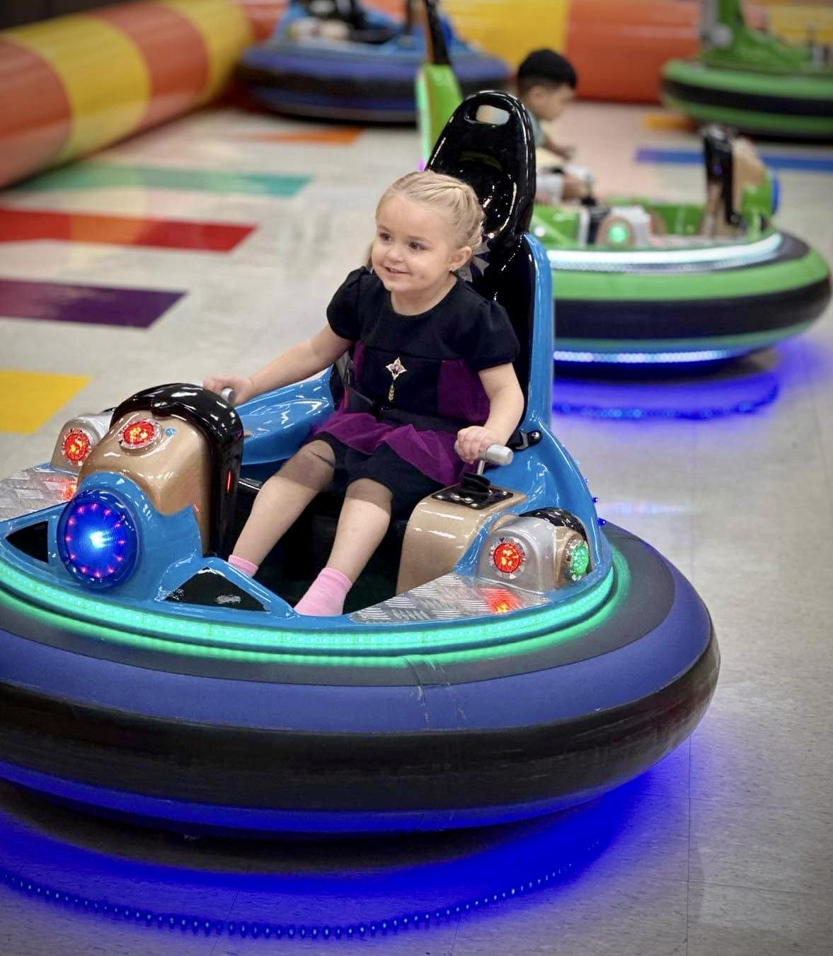 A young girl riding a bumper car