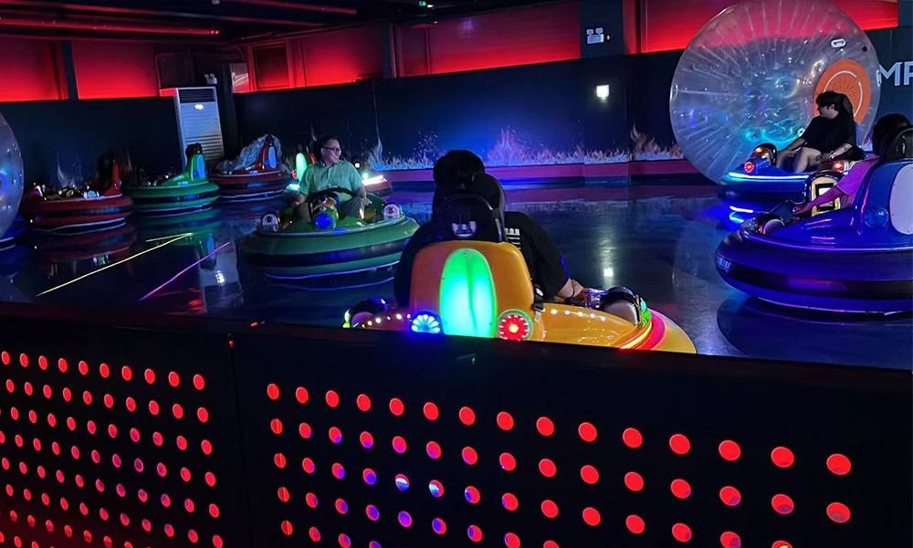adults riding bumper cars with colorful LED lights in a dark amusement park - H.Q.Amusement