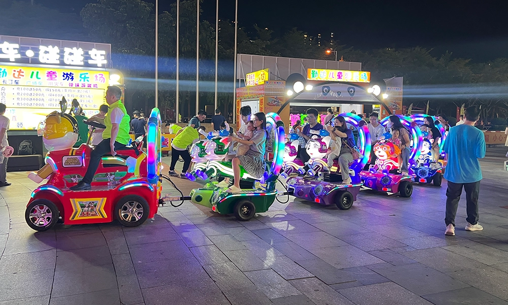 Children and adults ride nailong escort trackless train at night outdoor amusement area - H.Q.Amusement