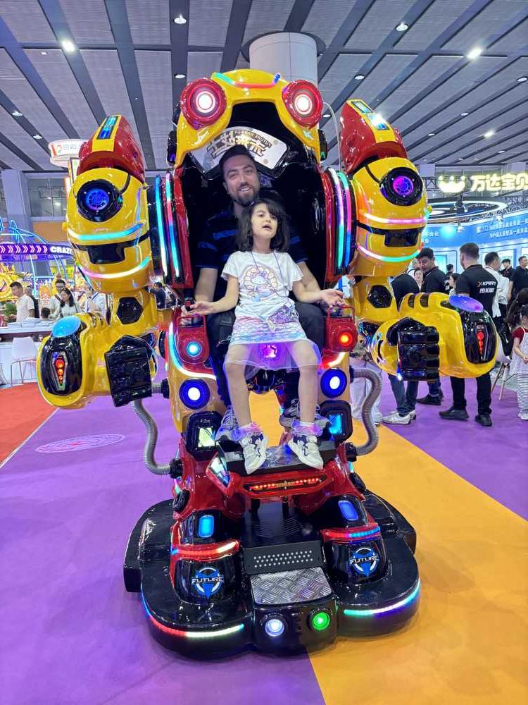 Father and daughter riding Future Warrior robot ride