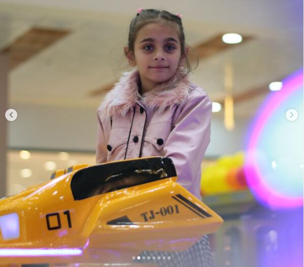 Girl riding a Kiddie Armored Robot Ride