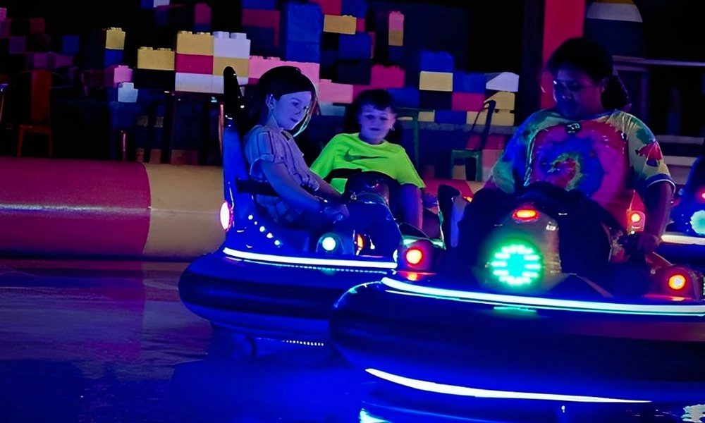 Kids riding glowing bumper cars at an indoor amusement park - H.Q.Amusement