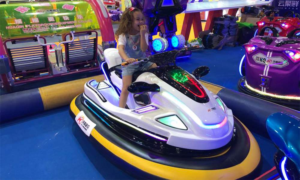 little girl at the exhibition rides the motorboat bumper car
