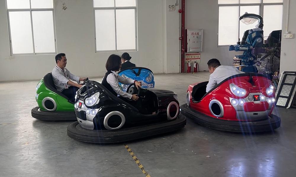 People riding in colorful parent-child bumper cars indoors