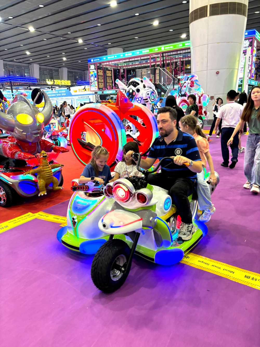 Three kids and one adult riding parent-child motorcycle
