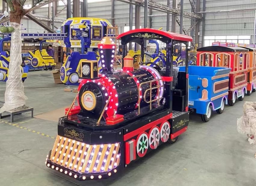 قطار مدينة ملاهي SUNHONG باللونين الأسود والأحمر، مع عربات ركاب ملونة، معروض في مستودع، لعرض قدرات تصنيع قطارات بدون مسارات وقدرات الإنتاج في المصنع - SUNHONG