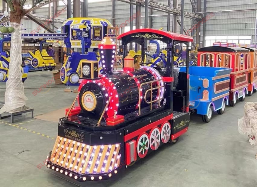 sunhong-amusement-park-train-ride-black-red-trackless-train-warehouse Black and red SUNHONG amusement park train ride with colorful passenger cars displayed in a warehouse, showcasing trackless train ride manufacturing and factory production capability