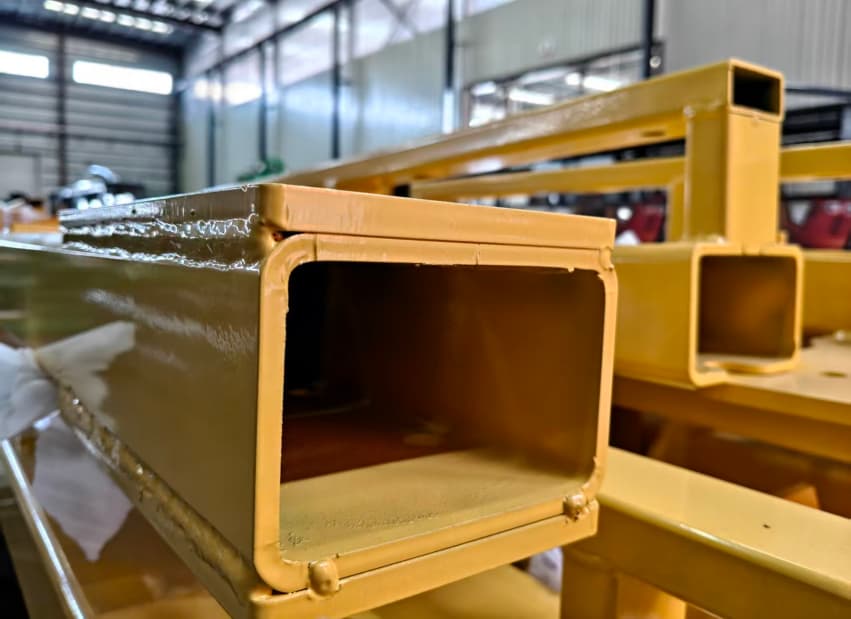 مقطع فولاذي مستطيل مجوف يُستخدم في إنتاج قطارات مدينة الملاهي من شركة SUNHONG، لعرض مواد عالية القوة لتصنيع قطارات بدون قضبان في بيئة المصنع لمعدات مدن الملاهي - SUNHONG