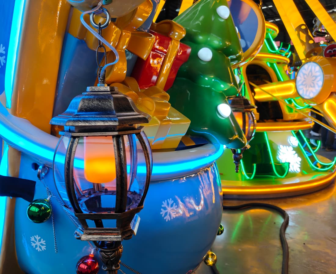 Glowing lantern hanging from a colorful Christmas-themed amusement park ride. - SUNHONG