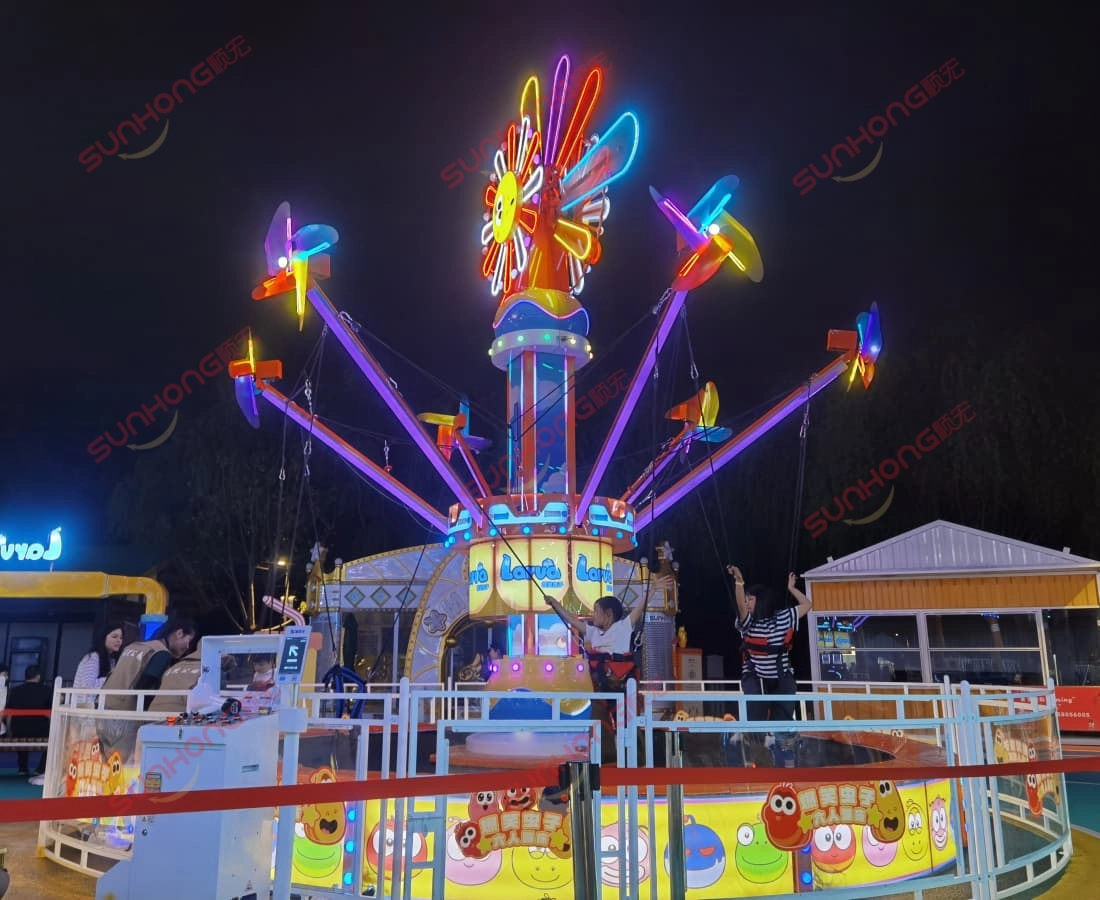 3D-front-view-of-the-Larva-Windmill-Trampoline-with-a-red-gradient-background. - SUNHONG Two children playing on the Larva Windmill Trampoline at night in a Larva-themed amusement park. - SUNHONG