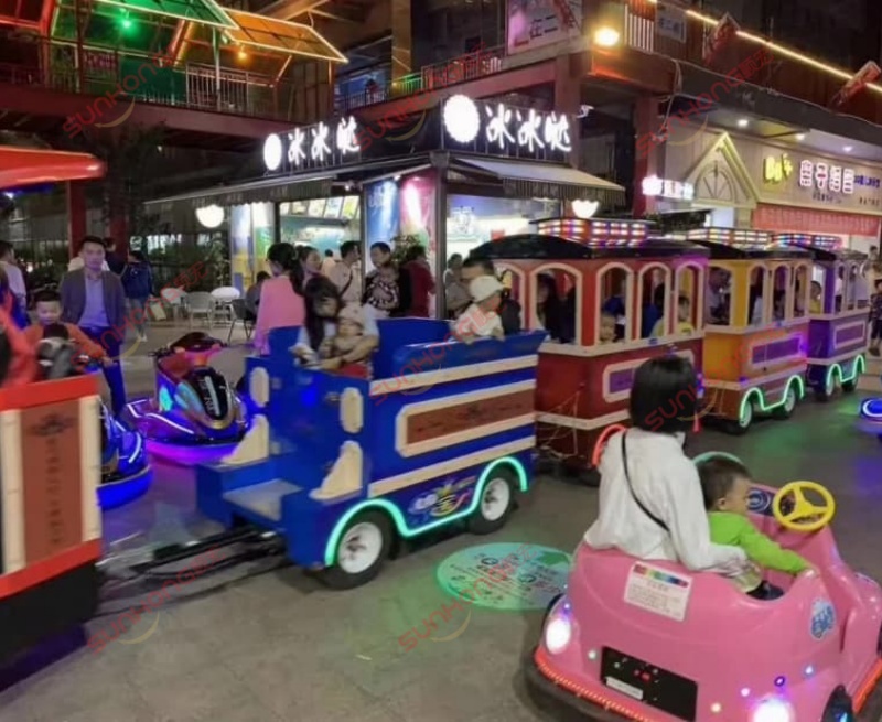 sunhong-amusement-park-train-ride-night-led-operation Children riding a SUNHONG amusement park train ride at night with illuminated car rides, showcasing a vibrant theme park entertainment atmosphere