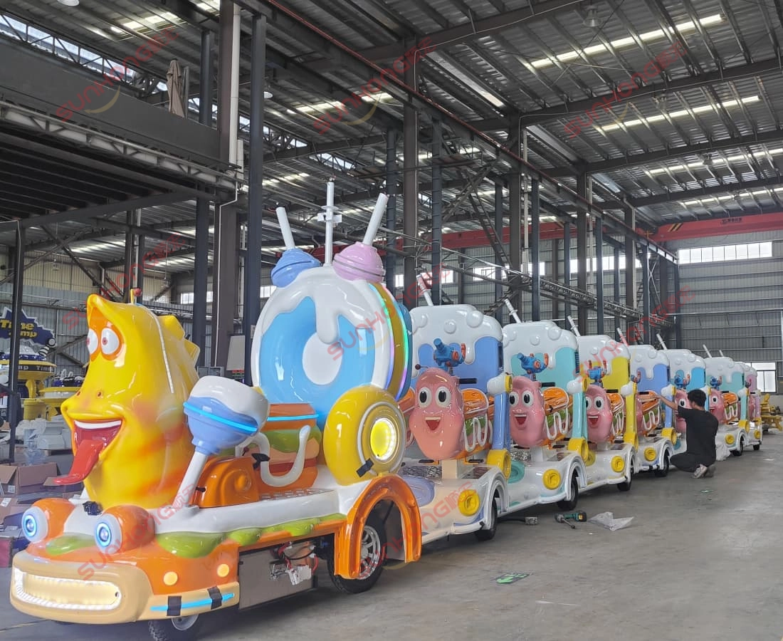 出售的 Larva Ranger 无轨火车摆放在 SUNHONG 工厂前,以黄色和红色字符为特色,背景为 SUNHONG 徽标。 - SUNHONG SUNHONG技术人员在生产车间内调整出售的Larva Ranger无轨小火车的座椅——质量检验正在进行中。 - SUNHONG